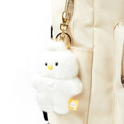White fluffy keychain attached to a beige backpack