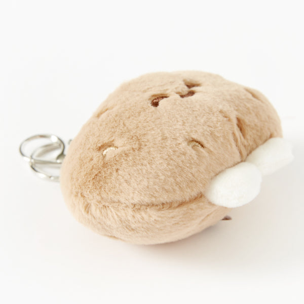 Plush keychain shaped like a potato with a white feet on a white background
