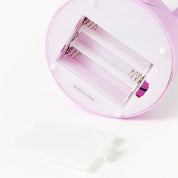 Battery insert for pastel pink mood light on a white background