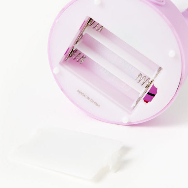 Battery insert for pastel pink mood light on a white background