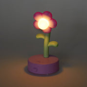 Flower-shaped night light with a glowing bulb on a dark background