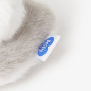 Close-up of a soft, gray fabric with a visible brand label on a white background