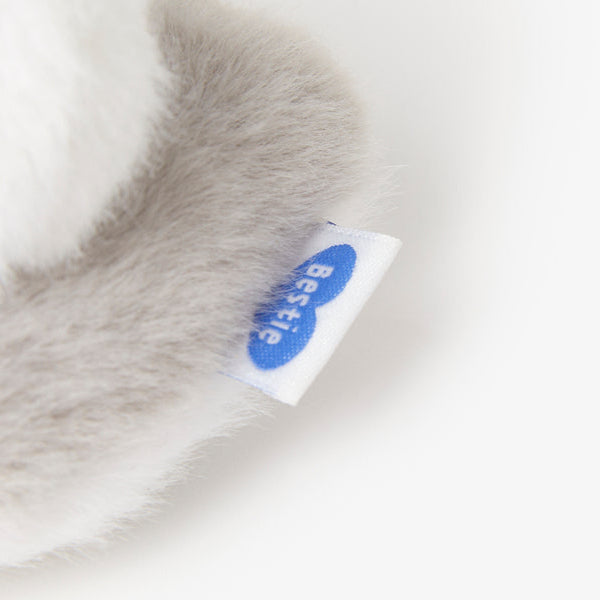 Close-up of a soft, gray fabric with a visible brand label on a white background