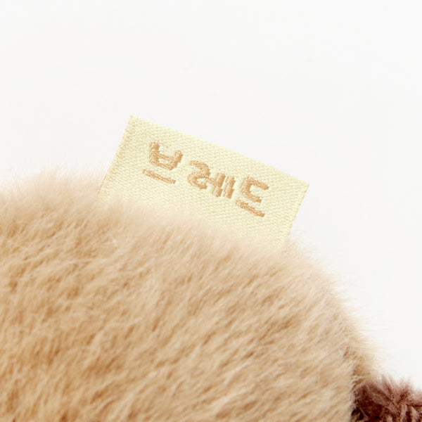 Close-up of a plush toy with a label on a white background