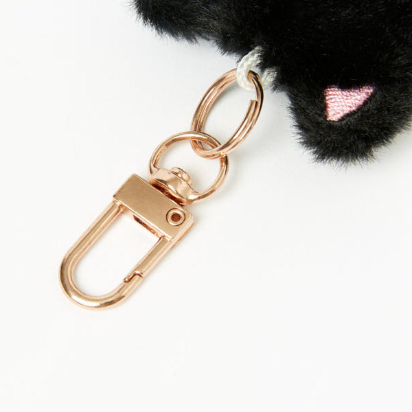 Black fluffy keychain with a rose gold clasp on a white background