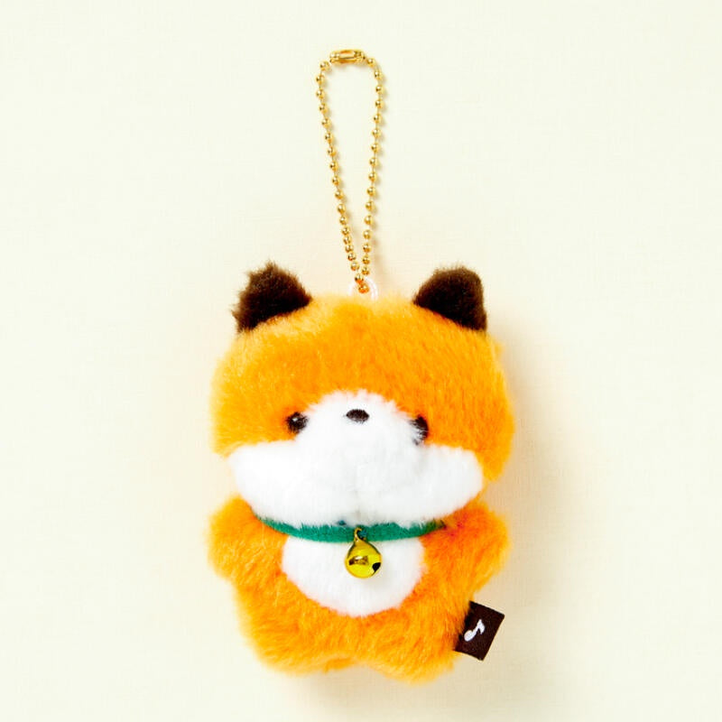 Plush fox keychain with a gold chain on a beige background