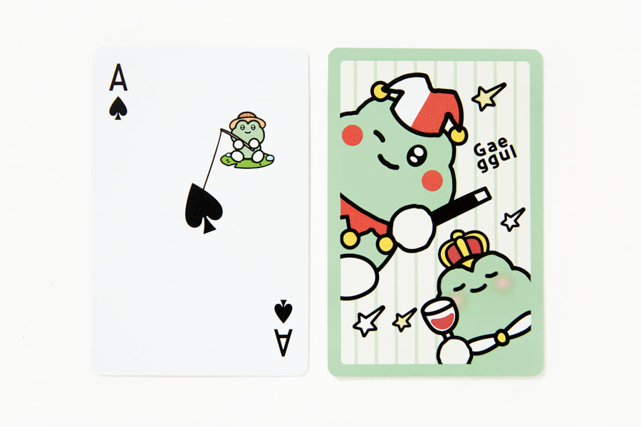 Cartoon character playing cards with a green dinosaur-like creature and a small frog on a white background.